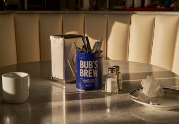 Lifestyle composition of Bub's Brew with cups and napkin dispenser and stark shadows